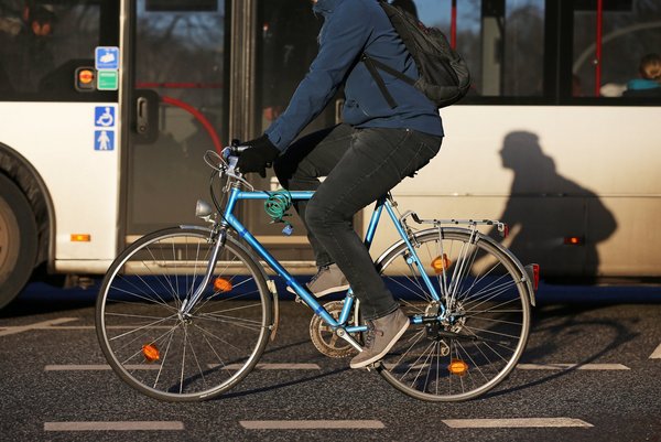 Symbolbild: Fahrrad vor Bus im Straßenverkehr