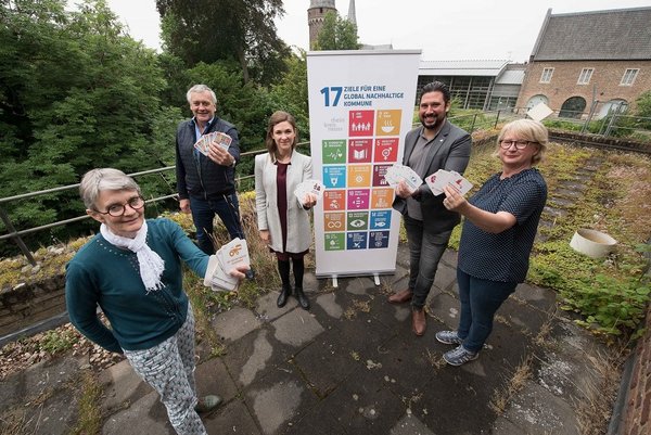 5 Personen halten Bierdeckel hoch