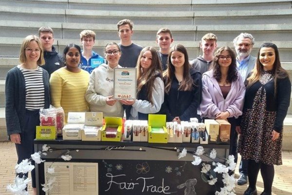 Mitglieder der Fairtrade-AG stehen vor einem Tisch mit fairen Produkten