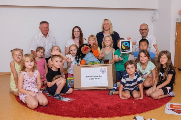 Foto von Landrat Hans-Jürgen Petrauschke (l.) mit Sabrina Katzmann (2.v.l. hinten), Leiterin des Familienzentrums Regenbogen, der stellvertretenden Leiterin Katharina Esch (2.v.r. hinten), Kreissprecher Benjamin Josephs (r.) und den Vorschulkindern