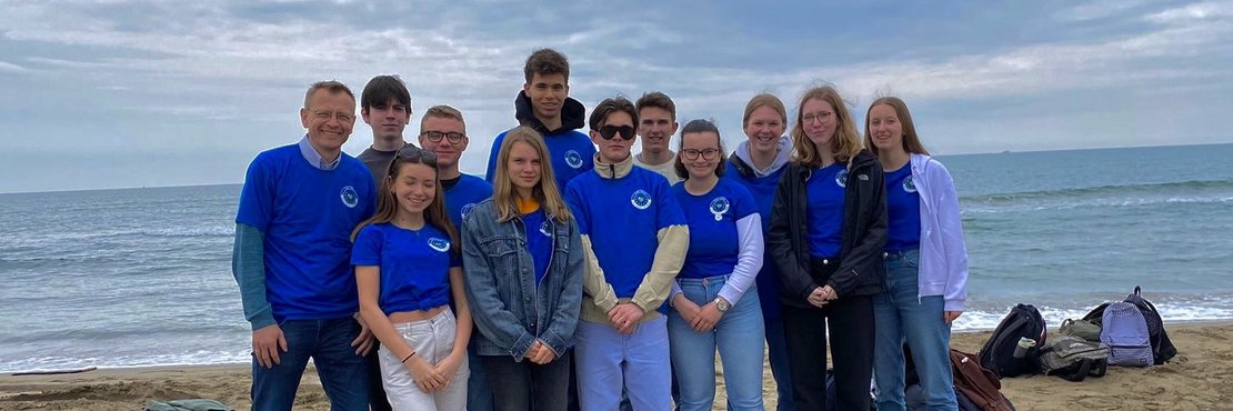 Eine Gruppe Jugendliche des Norbert-Gymnasiums Knechtsteden stehen am Strand