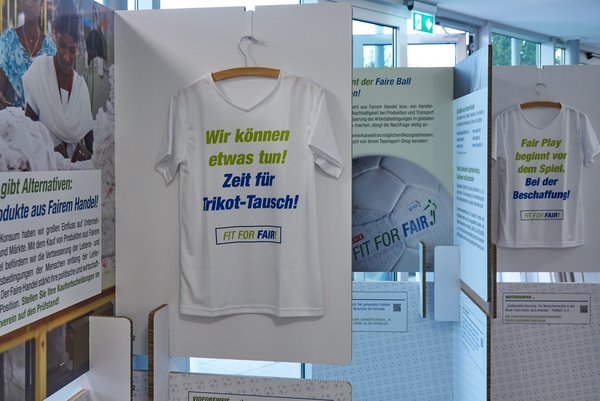 Ein T-Shirt mit der Aufschrift "Wir können etwas tun" Zeit für Trikot tausch" hängt an einem Haken