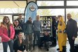 Mehrere Schüler und Lehrer vor einem Snackautomaten.
